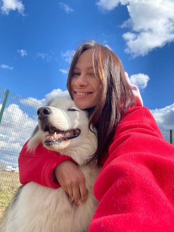 Woman embraces white dog in outdoor scene, Sokol Russia