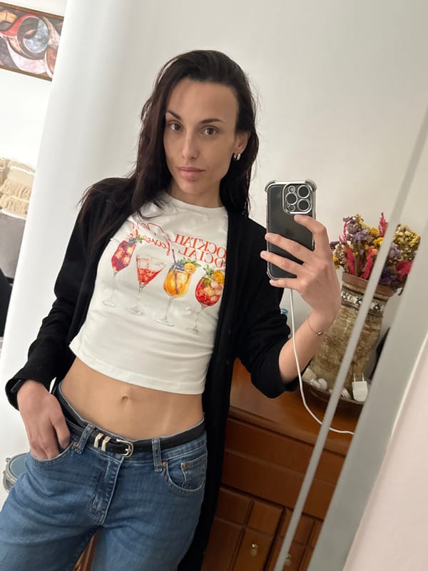 Woman takes mirror selfies in cocktail graphic top, Chania