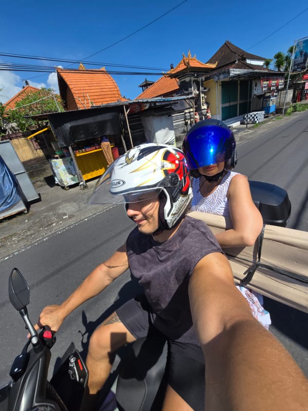 Two people take motorcycle selfies in sunny Kediri, Indonesia
