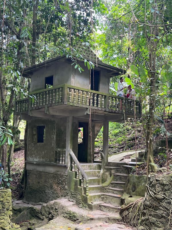 Overgrown jungle shrine with stone statues in Ko Samui
