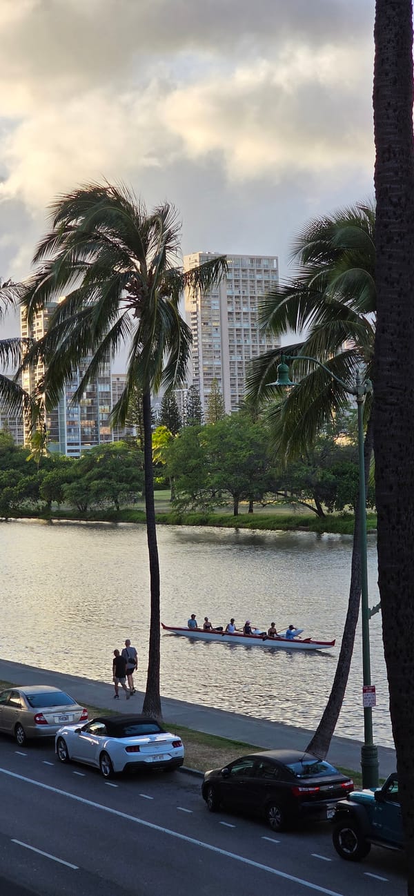 Outrigger canoe crew paddling calm Hawaiian waters