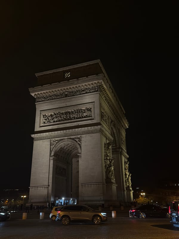 Arc de Triomphe glows under night lights in Paris