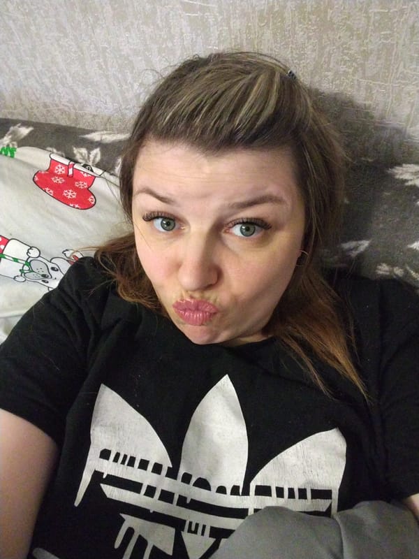 Woman makes kissing face on bed in Rusanovo