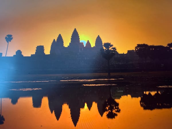 Angkor Wat's five towers in silhouette at sunrise