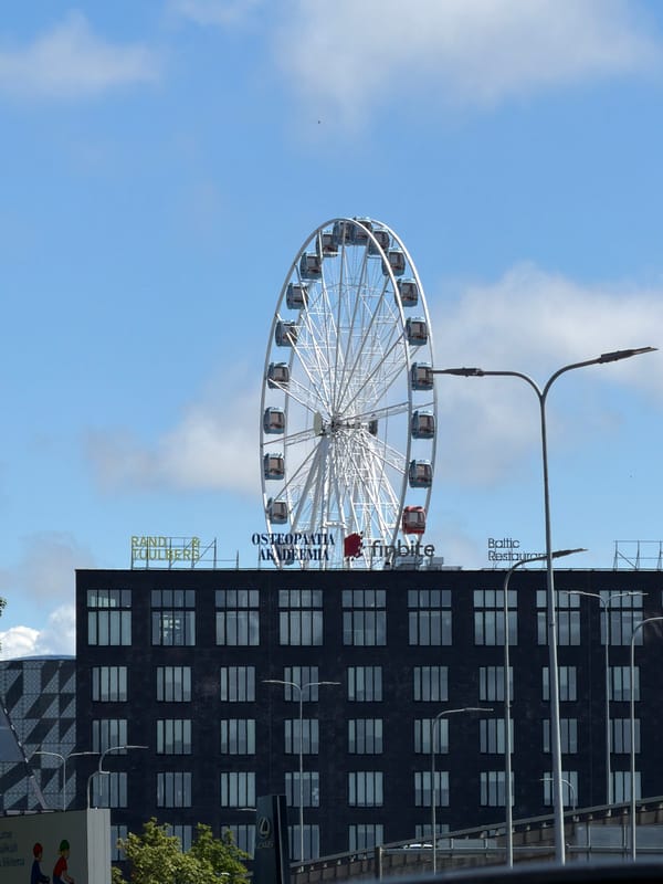 Ferris wheel and industrial chimney share Tallinn's mixed skyline