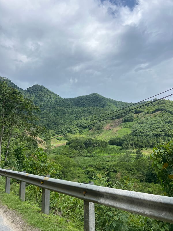 Mountain road winds through forested hills of Minh Tân Commune