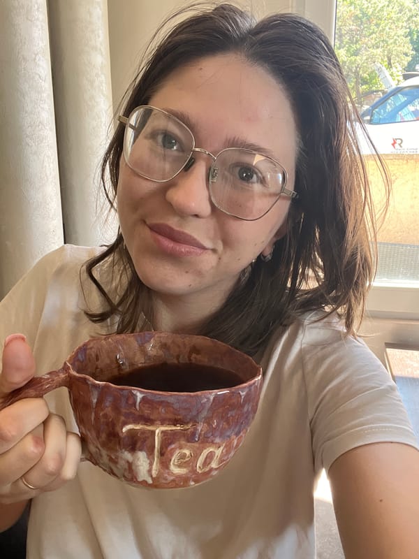 Woman displays ceramic mug indoors in Podgorica