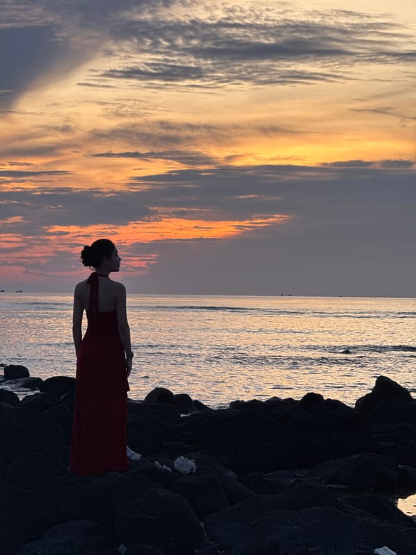 Sunset on Lý Sơn Island: red dress, rocky shore, lighthouse