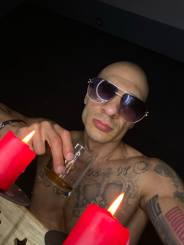 Tattooed man photographed with drink and cigar in Pleven