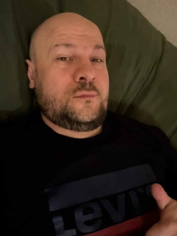 Man takes casual selfies on couch in Almaty apartment