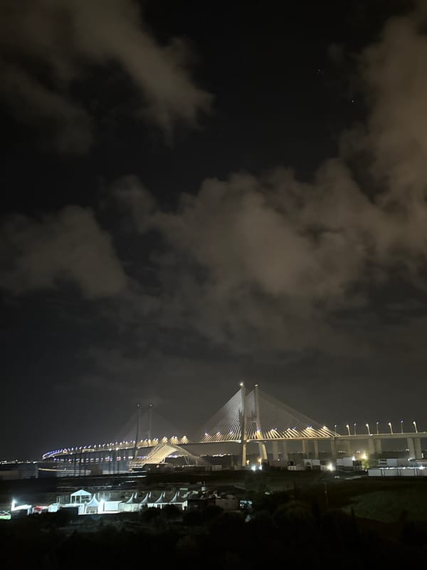 Illuminated bridge lights up night sky in Loures, Portugal
