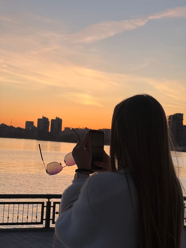 Woman watches sunset from Kazan waterfront promenade