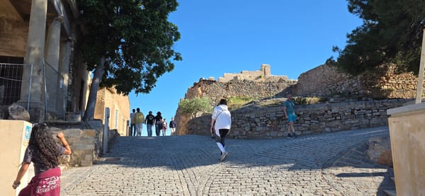 Tourists explore historic Sagunto Castle ruins on spring afternoon