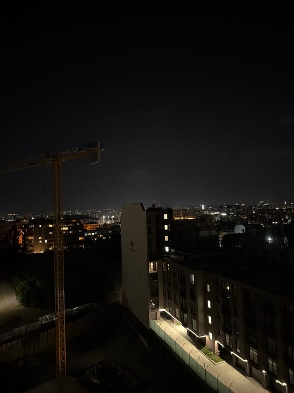 Sofia streets at night: cranes, lamplight, and a parked BMW