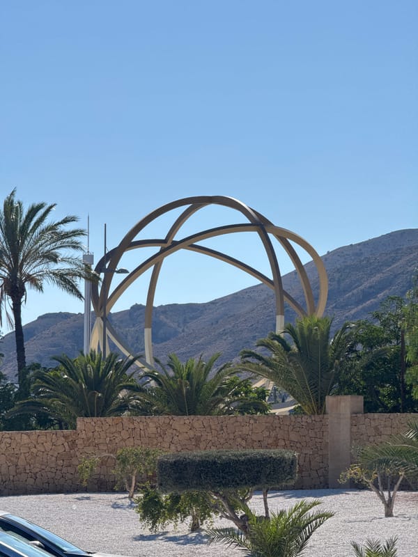 Benidorm's skyline, sculptures, and landscaping on a sunny afternoon
