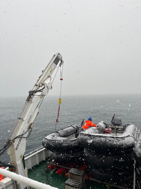 Crane lifts snow-covered boats in maritime operation