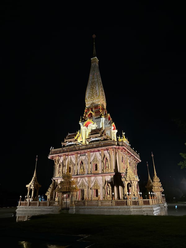Wat Chalong temple glowing at night, reflection on water