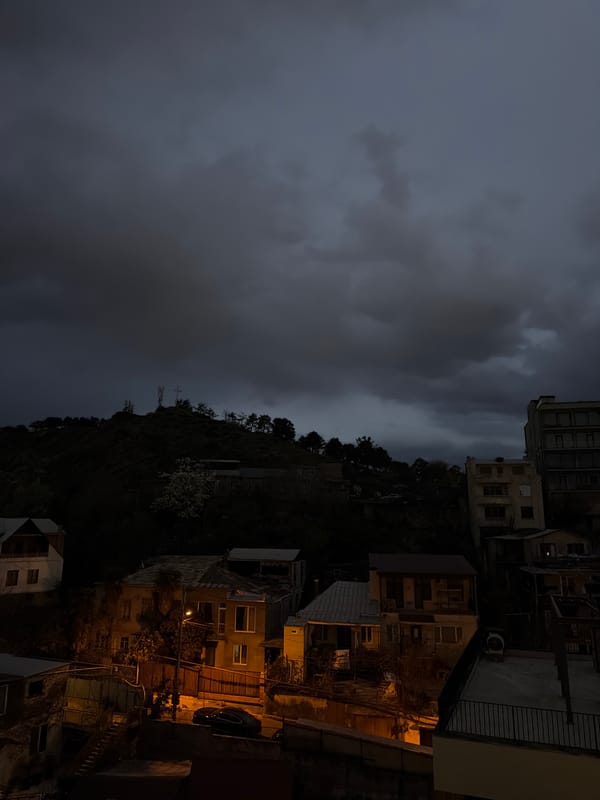 Nighttime hillside buildings illuminated in Tbilisi, Georgia