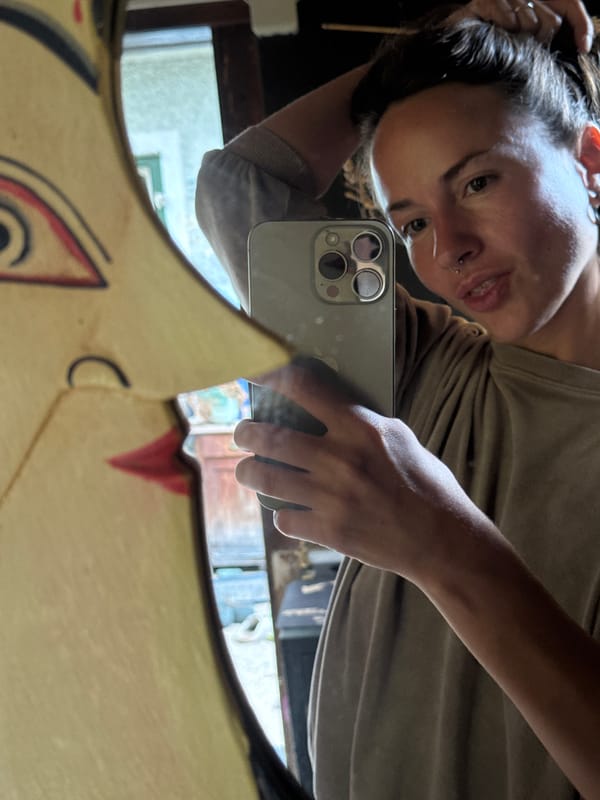 Mirror selfies in front of a quirky wooden face frame