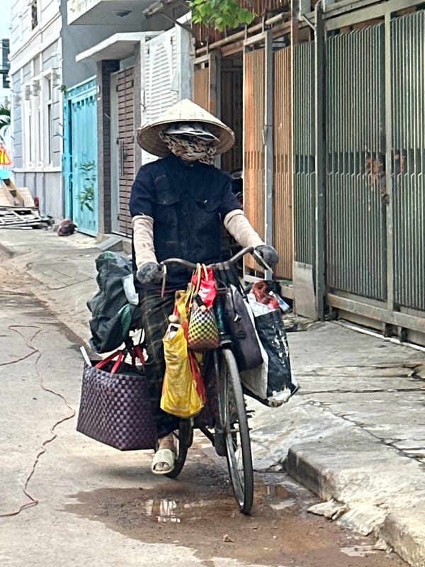 Morning street activity in Đà Nẵng — bicycle hauler and Grab rider