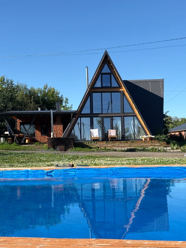 Summer group gathering at a lakeside A-frame in Zav'yalovo