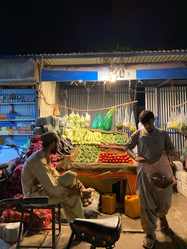 Night market vendor tends produce stall in Kandahar