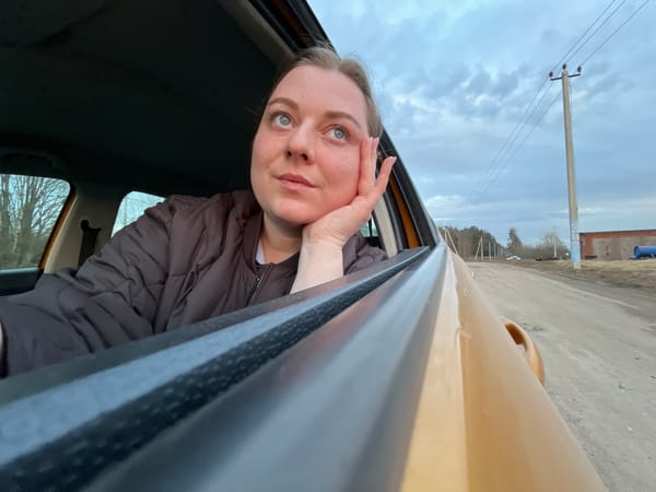Woman poses in car window in Pliuskovo, Russia