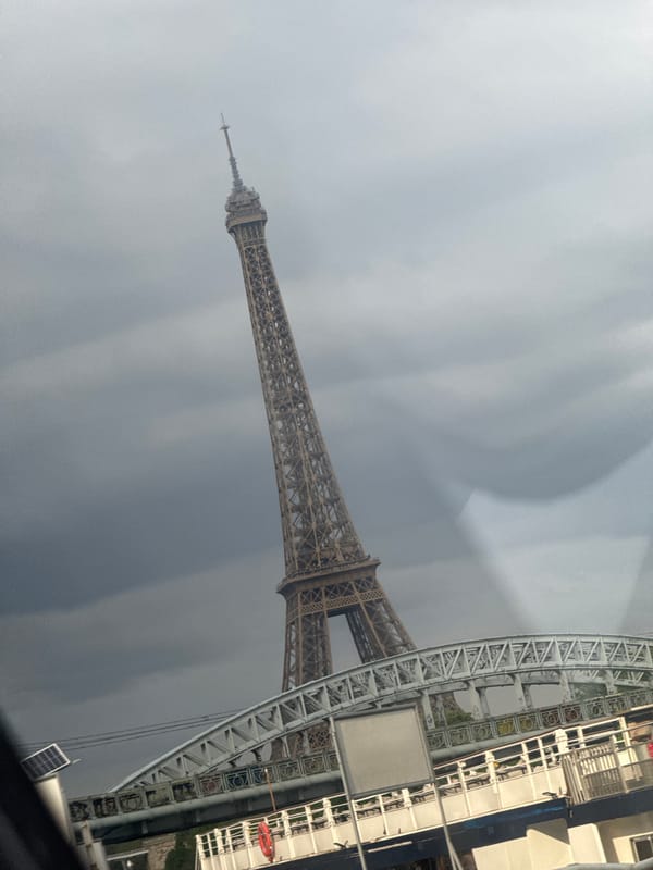 Paris landmarks viewed from moving vehicle under cloudy skies