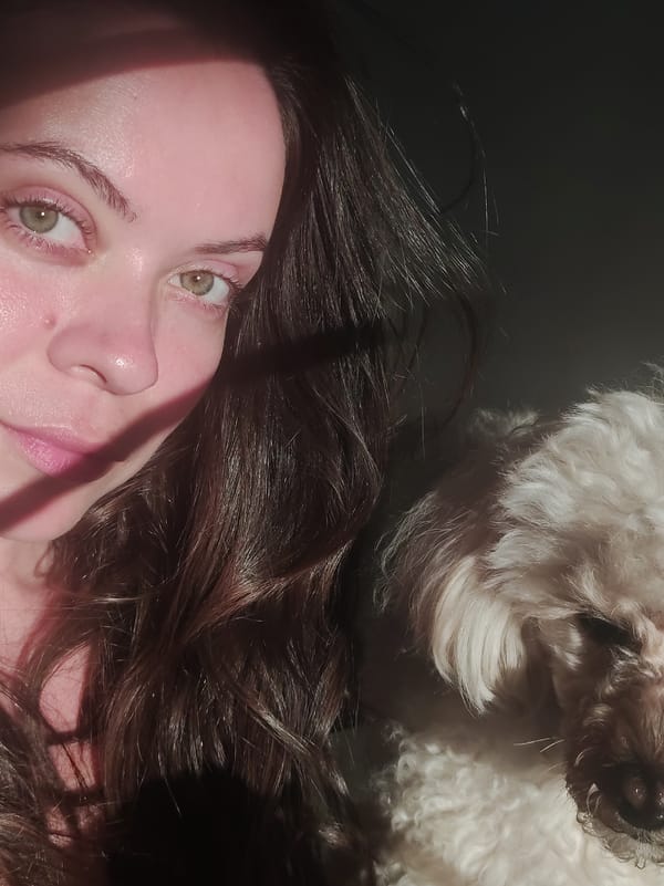 Woman takes selfie with dog in sunlit photograph