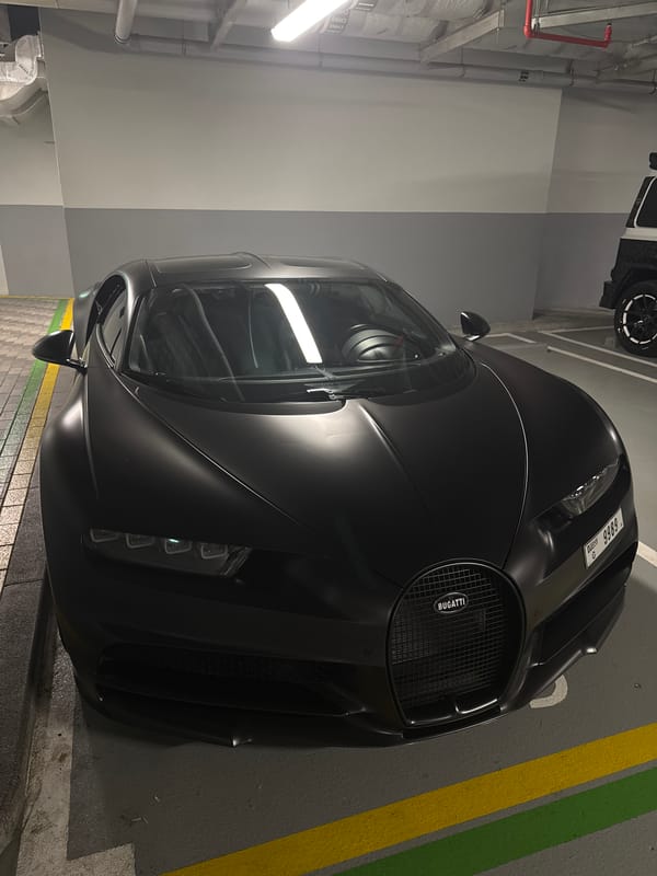 Dubai luxury cars and illuminated Burj Al Arab captured evening