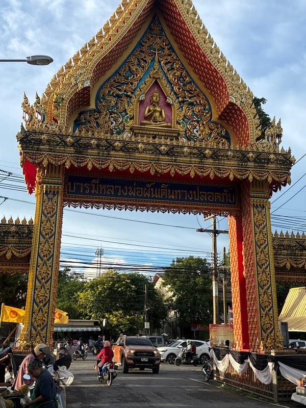 Ornate Buddhist gateway and street life in Si Sunthon