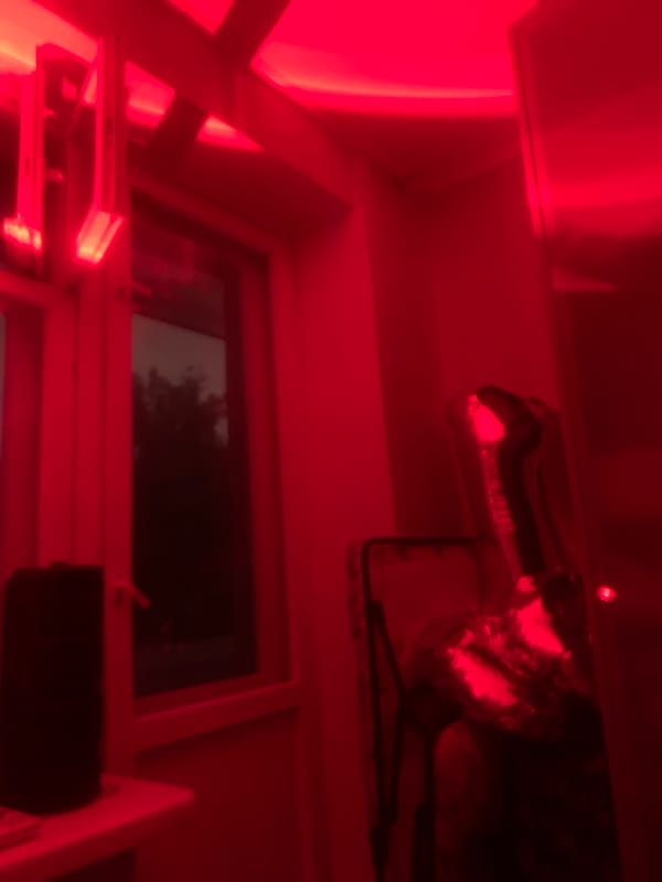 Red-lit indoor scene with balloon, person observed evening hours