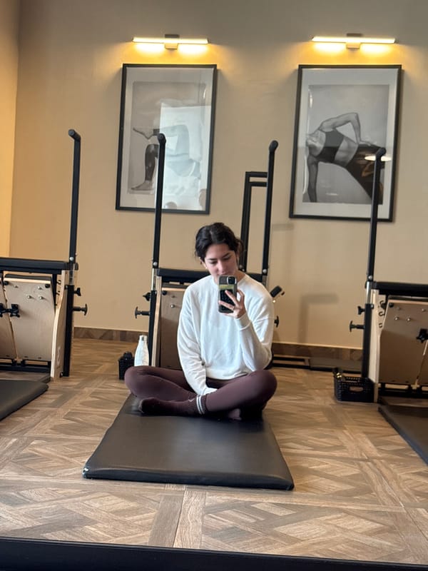 Woman takes selfie on pilates equipment in Mexican fitness studio