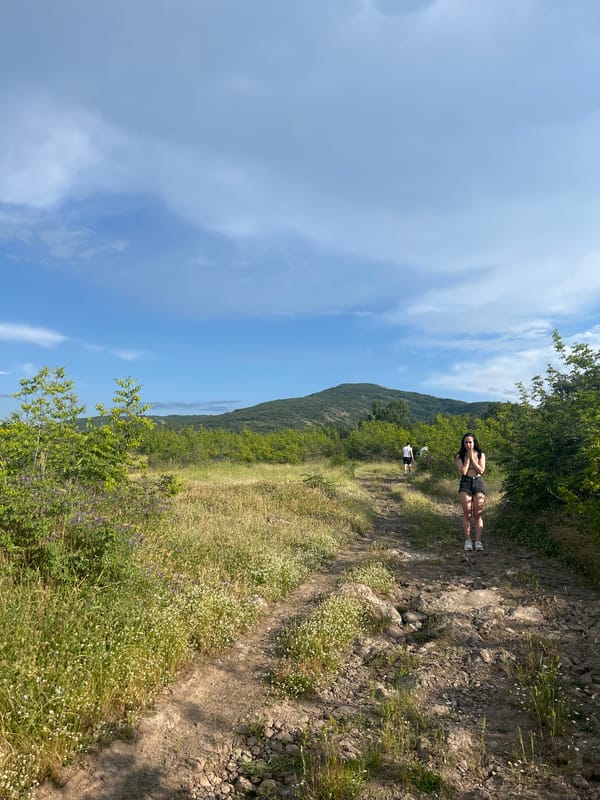 Woman stands on dirt path in Bulgarian village