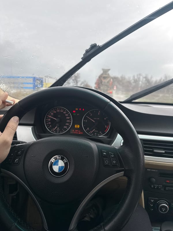 Driver navigates BMW through morning rain in Varna