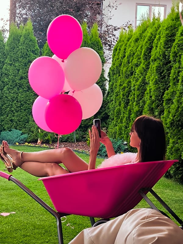 Pink-themed backyard party with balloons, snacks, and styled seating