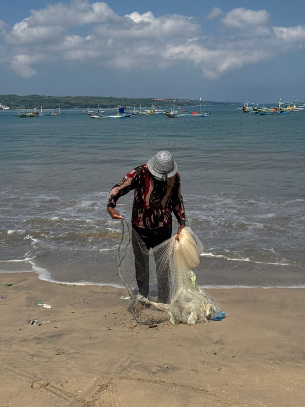 Traditional fishermen launch boats, prepare nets on Kuta beach