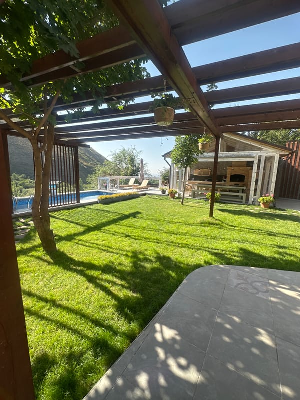 Backyard pool and pergola setup in sunny Almaty