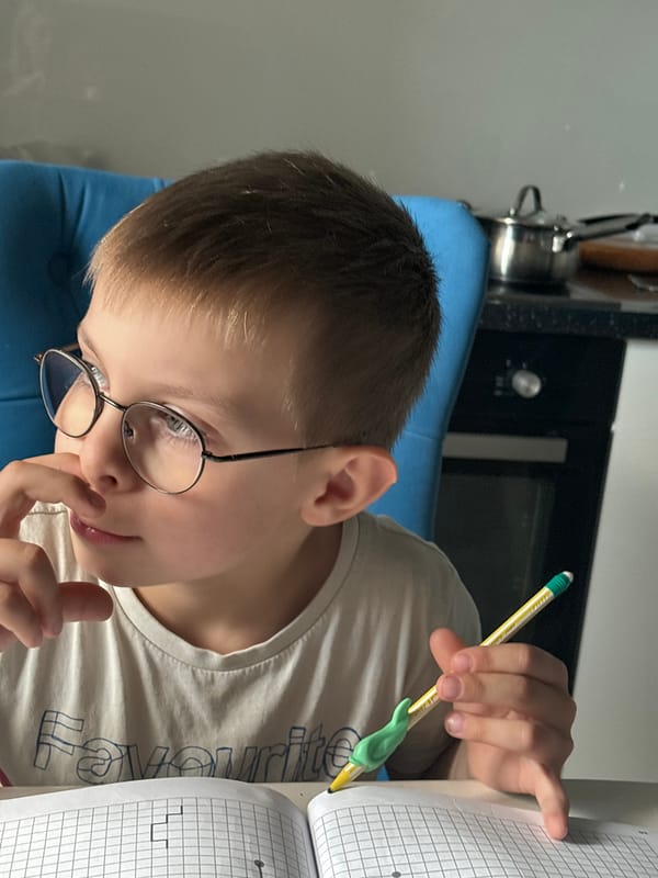Boy with glasses observed indoors, street traffic captured Russia
