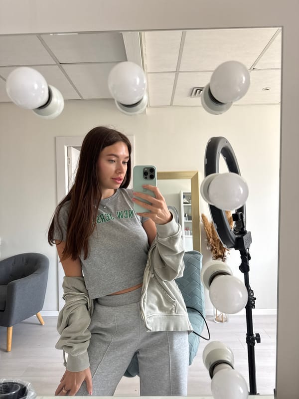 Woman stands before illuminated mirror in Ramat Gan interior