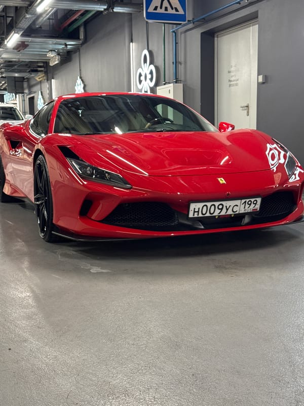 Red Ferrari F8 Tributo on display indoors in Moscow