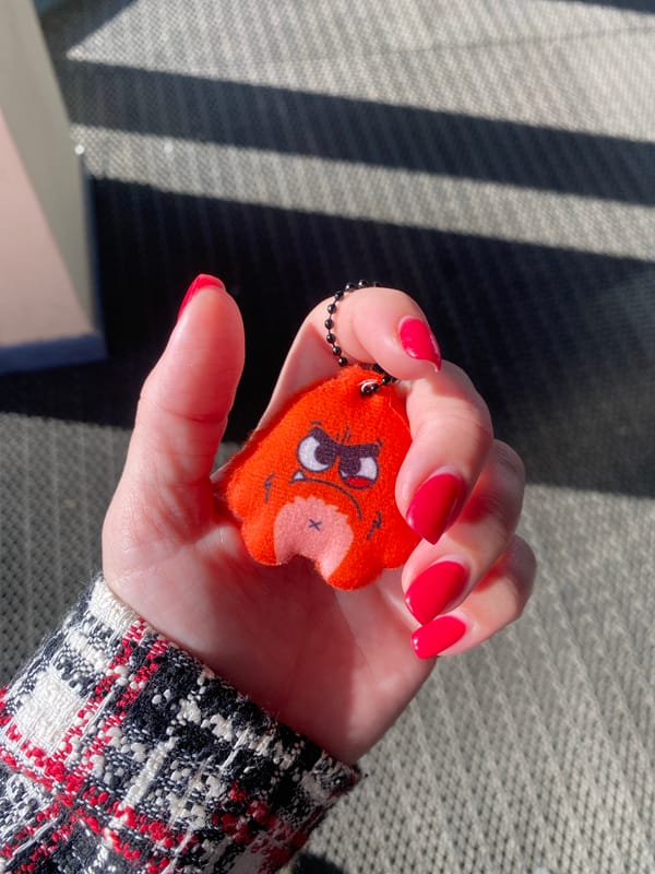 Person holds damaged orange plush keychain in Izhevsk