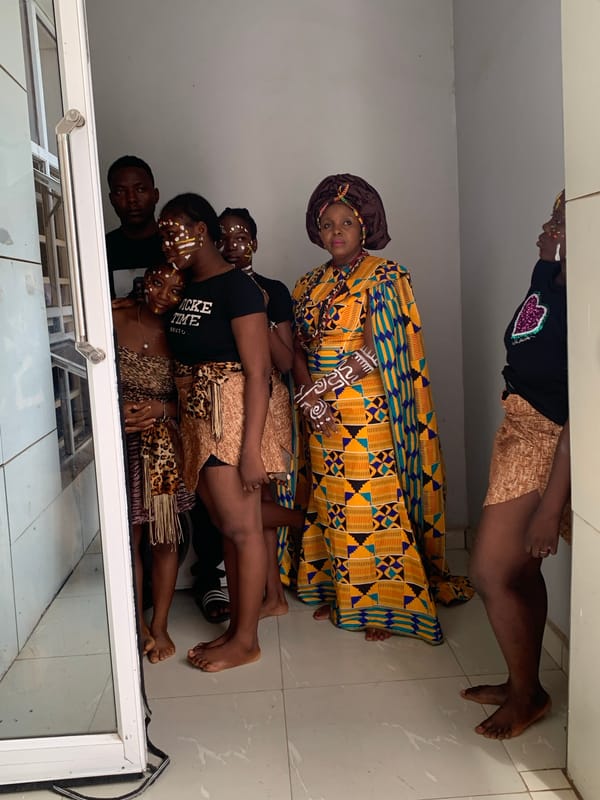 Group in traditional, modern African dress reflected in Akwanga glass
