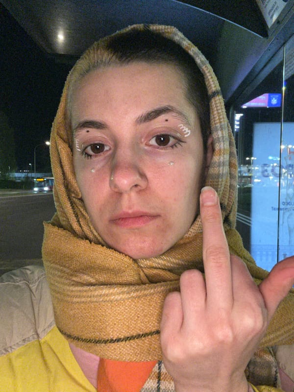 Two women dance on Belgrade sidewalk at night