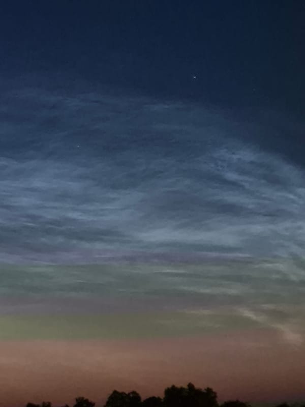 Summer twilight fades over the treeline in rural Estonia