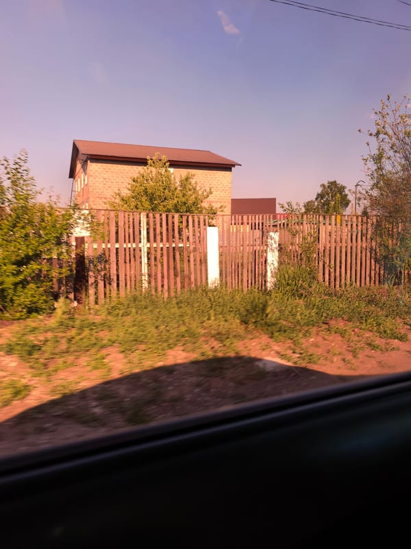 Brick house behind wooden fence observed in Sterlitamak, Russia