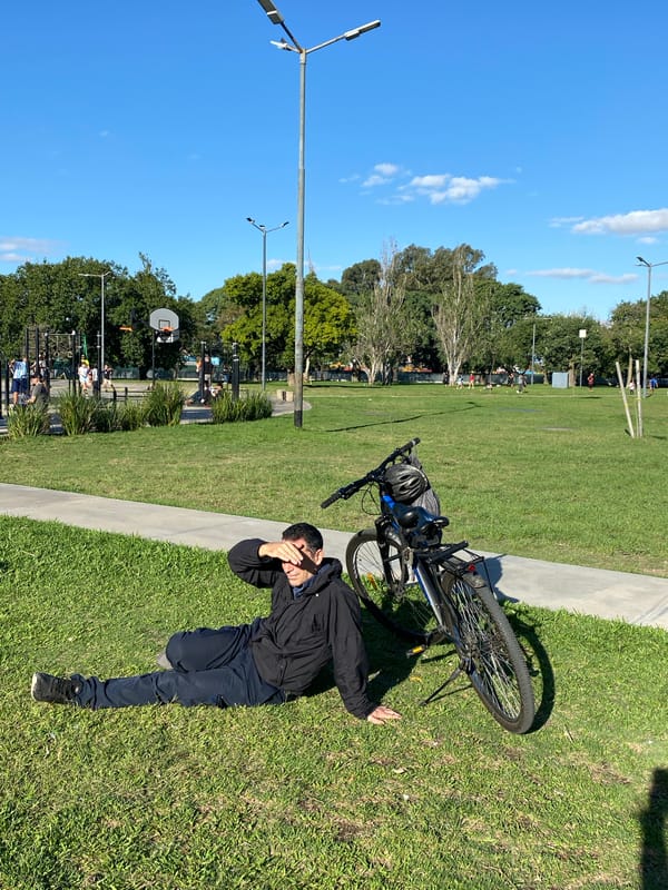 Evening park activity recorded around bronze sculpture in Buenos Aires