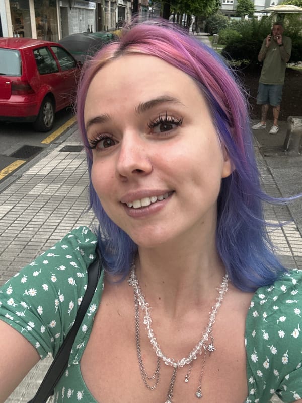 Woman takes selfie on sidewalk in Gijón, Spain