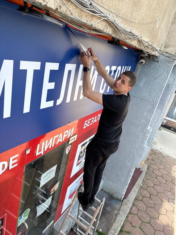 Man removes tape from tobacco store sign in Plovdiv