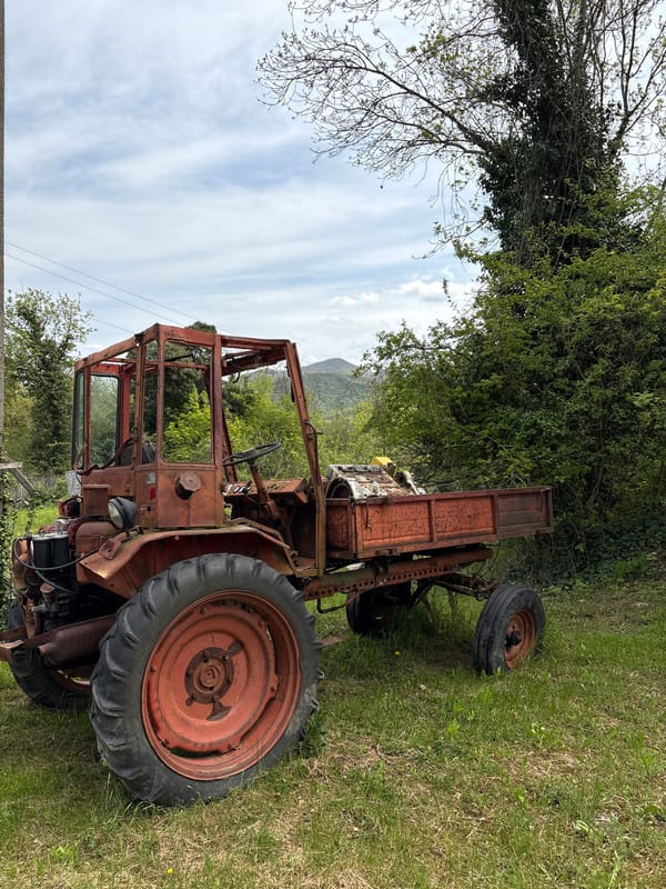Rural Russian village scenes captured: abandoned tractors, waterfalls, buildings